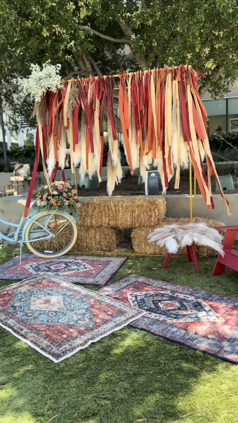 Boho ribbon fringe backdrop with hay bales and rugs